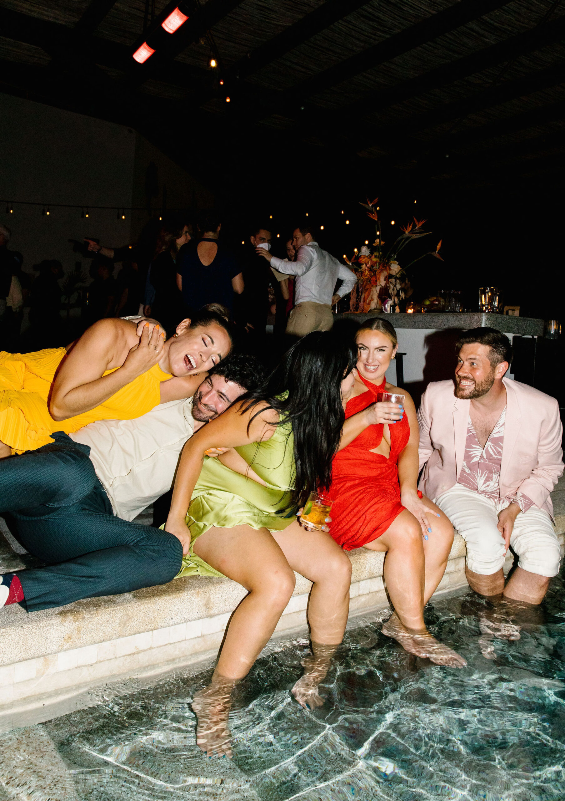 hotel el ganzo rooftop pool wedding dance party bride and friends dog pile beautiful extra large birds of paradise bar arrangement colorful wedding guest attire