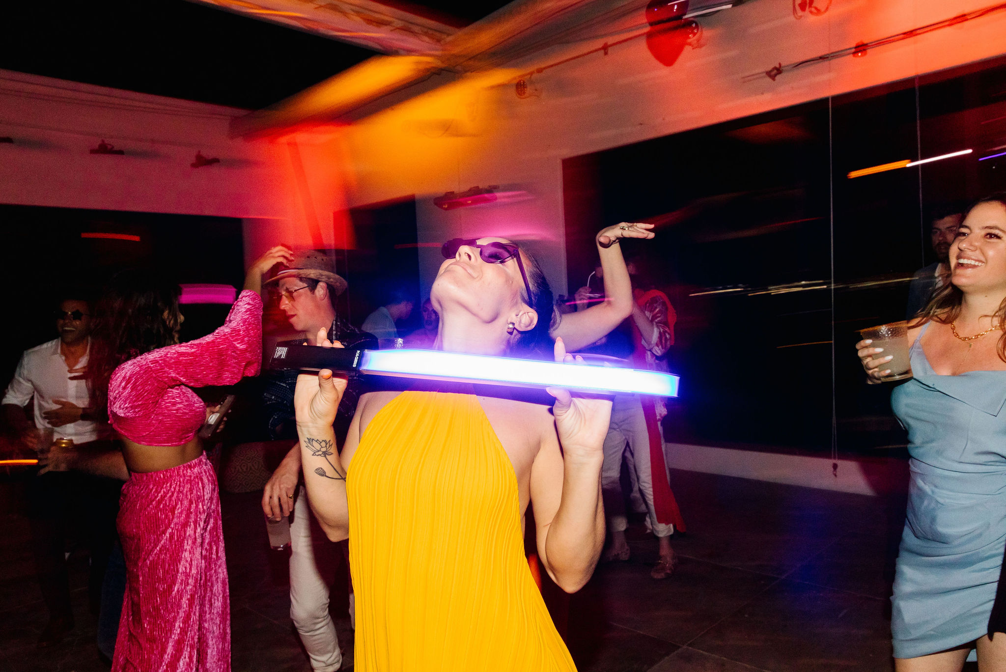 blurry photo style destination wedding dance party light sabor dance floor colorful yellow bridal after party dress