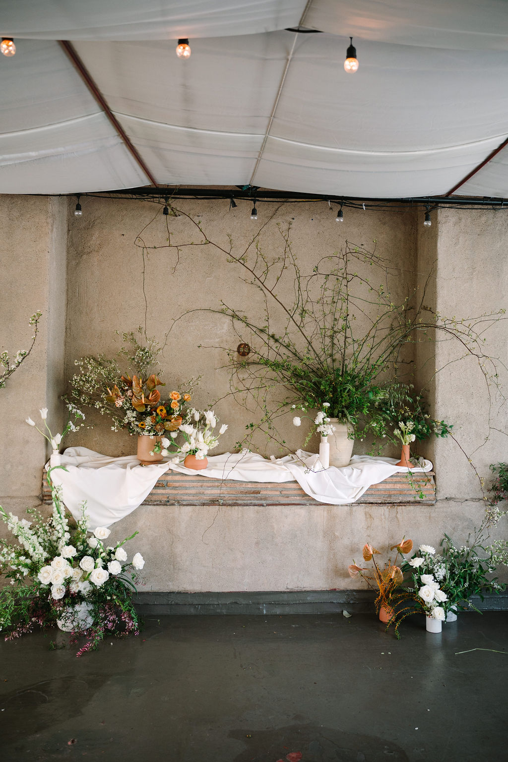 stone grand wedding vases dogwood wedding arrangements clean white florals with forest greens and pops of orange
white draped balcony wedding ceremony organic greens wedding ceremony unique alter ideas ethereal whimsical delicate greenery unique ceremony locations berkeley city club