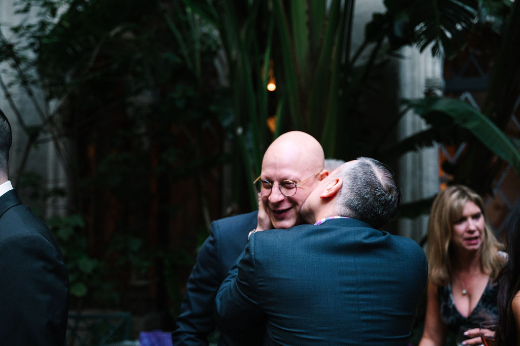 bride and groom dads kiss on cheek happy smiling candid celebrating love lush green courtyard berkeley city club 