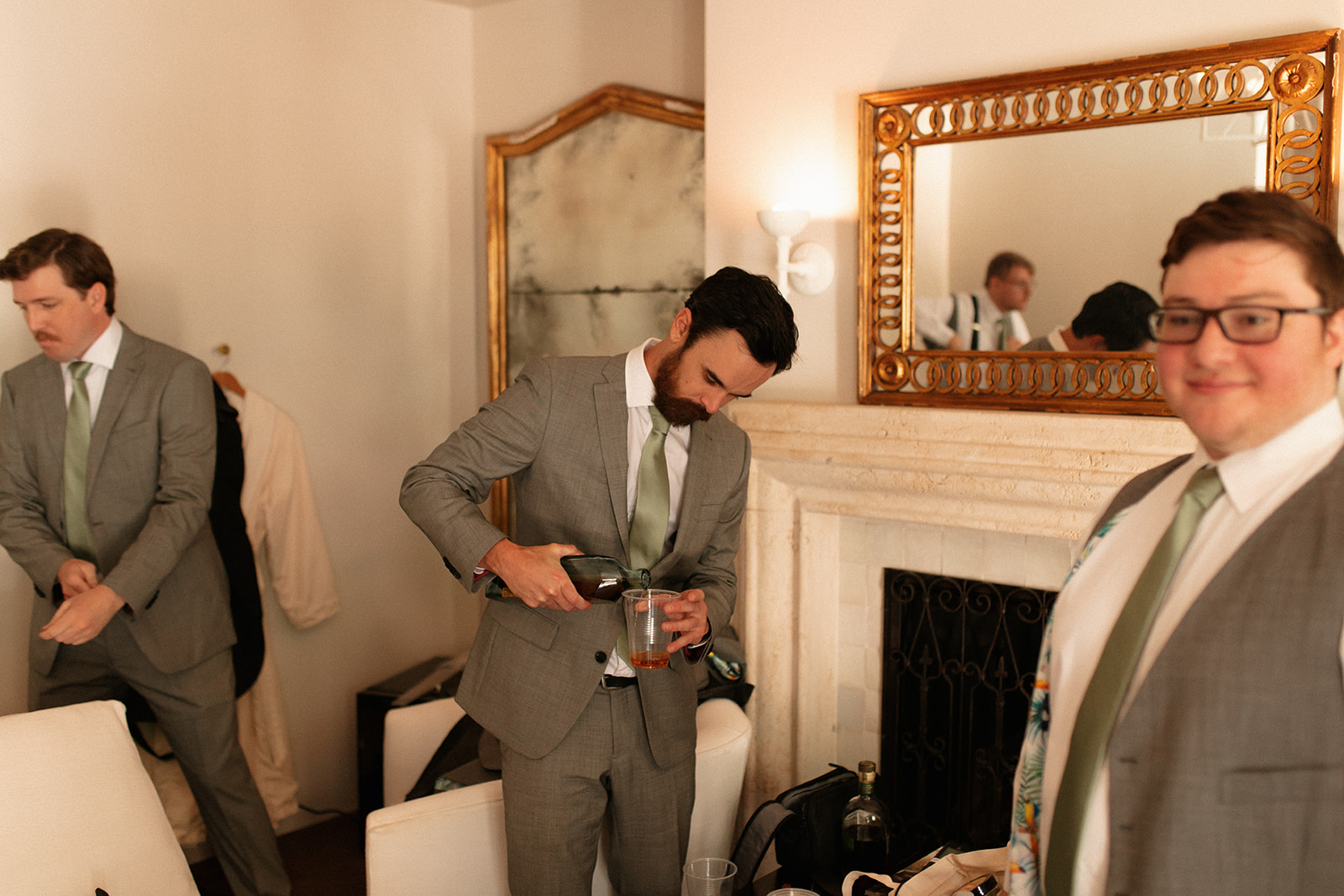 groomsmen getting ready sage green satin tie gray suits vintage mirrors marble white fireplace clean garden wedding