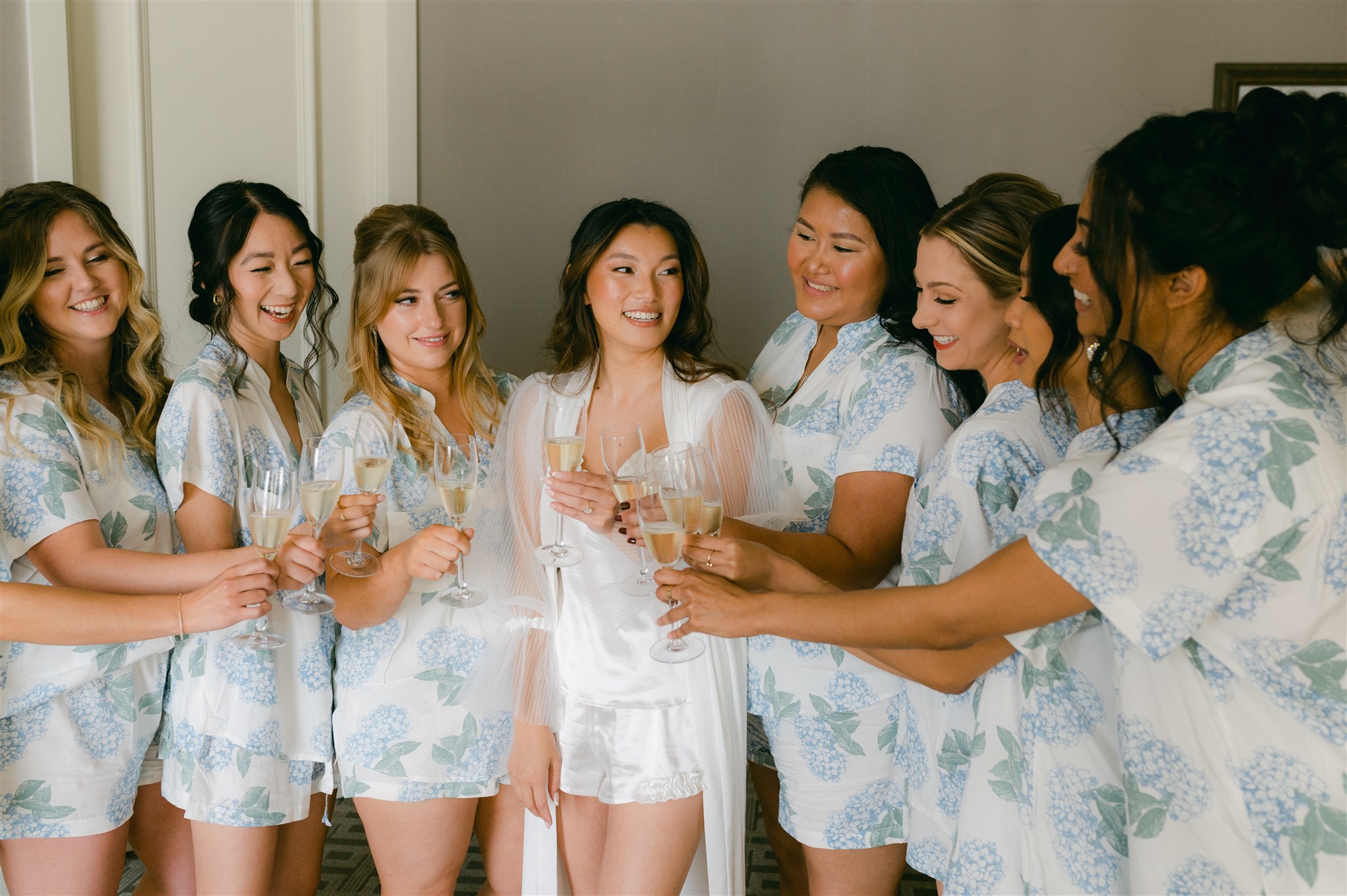 bride and bridal party bridesmaids getting ready champagne toast matching floral pajamas