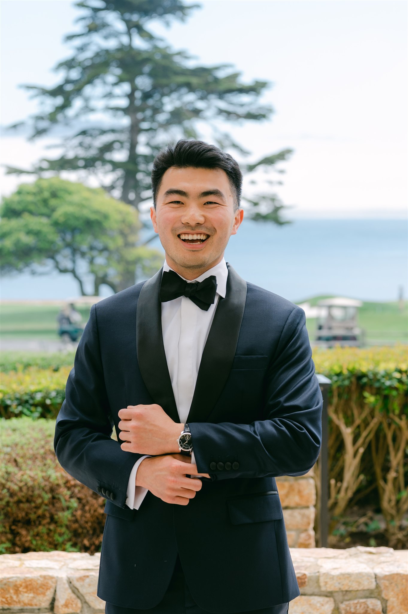 groom smiling happy joy dark navy blue suit with black details and black bowtie beach wedding carmel california