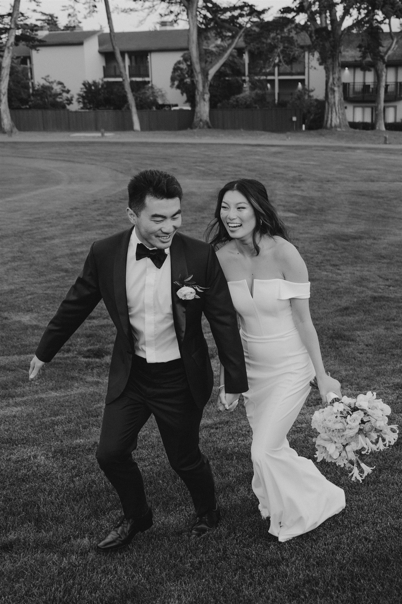 bride and groom portraits smiling candid black and white wedding shots bride and groom running away field happy candid joy