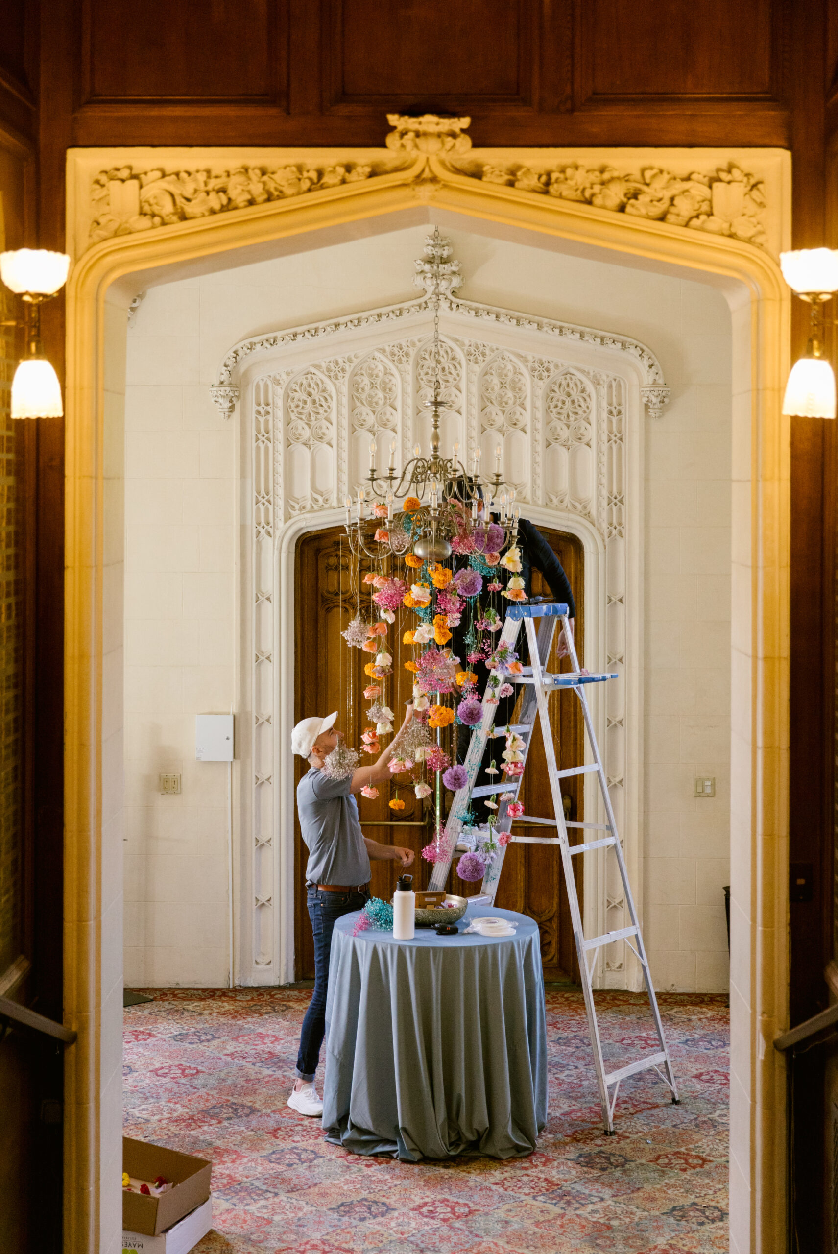 San Francisco Kohl Mansion Colorful City Wedding Ampersand SF setting up colorful floral chandelier gold regal carved doorway